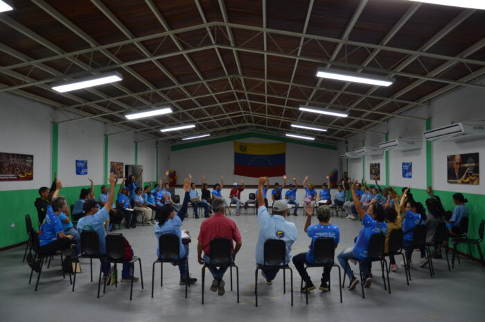 En sirkel med mennesker som stemmer over en sak med håndsopprekning